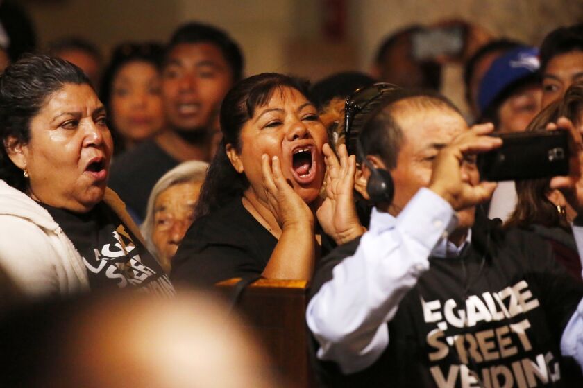 LOS ANGELES, CA - APRIL 17, 2018: Street vendors in the audience yell out as the L.A. City Council discusses the vote Tuesday April 17, 2018 to pass an ordinance on street vending, where brick-and-mortar businesses in Los Angeles would get a chance to try to stop vendors from setting up shop on the nearby sidewalks, but would not be able to automatically turn them down. (Al Seib / Los Angeles Times)