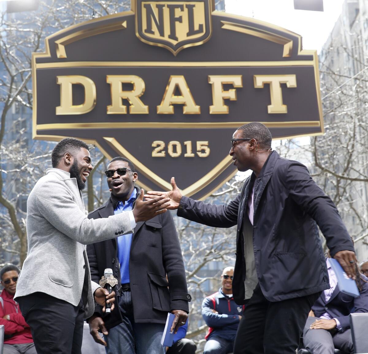 Alabama's Landon Collins, left, is greeted by Michael Irvin, center, and Cris Carter during introductions at a pre-draft event in Chicago on Wednesday. The NFL draft begins Thursday evening.
