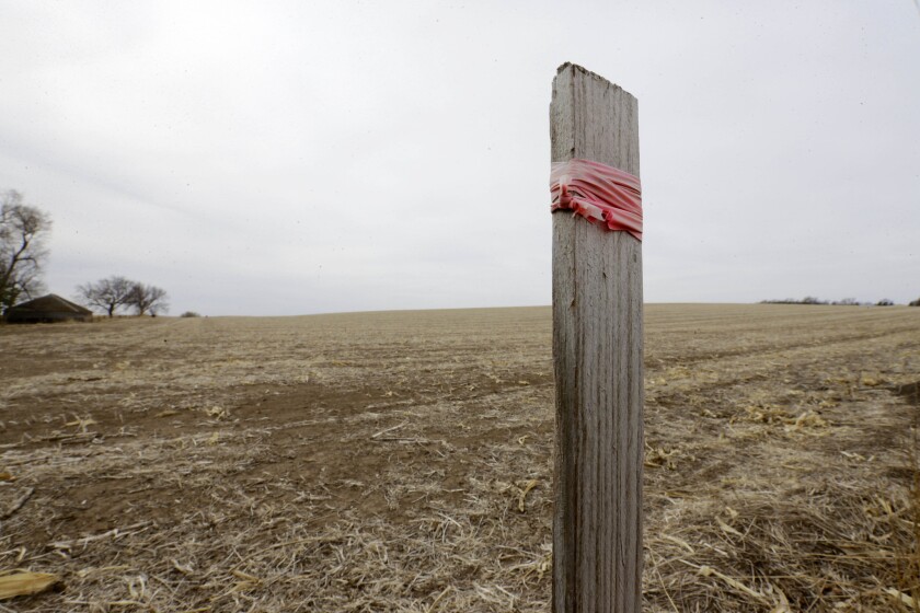 A stake in the ground wrapped with tape in this file photo marks the route of the Keystone XL pipeline in Tilden, Neb.