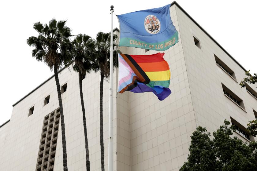 LOS ANGELES, CA - JUNE 01: The Progress Pride Flag flies over the Kenneth Hahn Hall of Administration for the first time in downtown on Thursday, June 1, 2023 in Los Angeles, CA. L.A. County Supervisors Janice Hahn, Hilda Solis, Kathryn Barger and Lindsey Horvath will join county Assessor Jeff Prang, and Sister Tootie Toot of the group the L.A. Sisters of Perpetual Indulgence to raise the Progress Pride Flag over the Kenneth Hahn Hall of Administration. It will mark the first time a pride flag has flown over a county building. (Gary Coronado / Los Angeles Times)