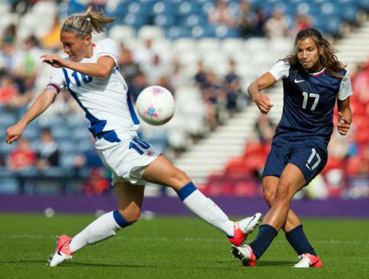 France's Camille Abily, left, attempts to stop a shot by Tobin Heath of the U.S.