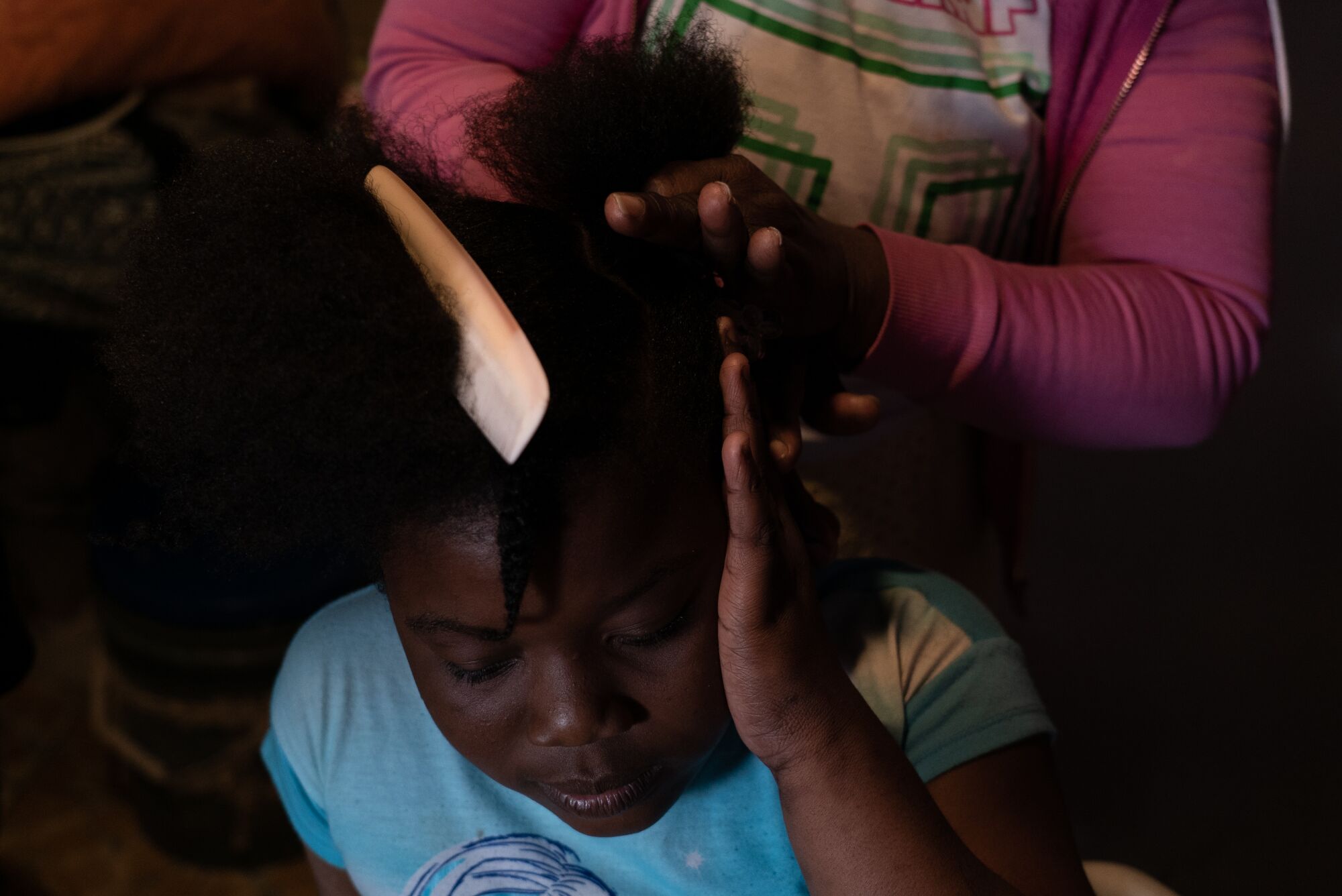 Antoinette Darelus helps her daughter, Dawendjina, with her hair before school.