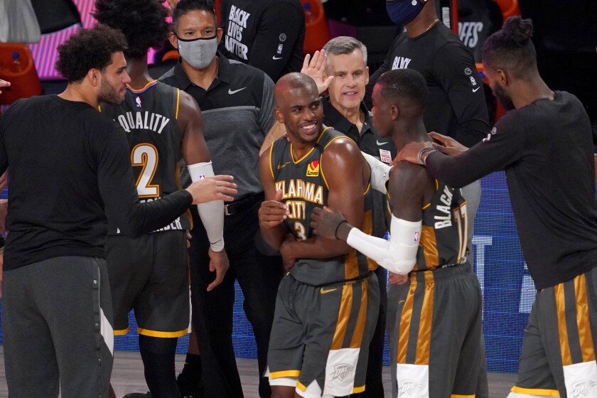 Oklahoma City Thunder's Chris Paul (3), Dennis Schroder (17), head coach Billy Donovan, center rear, and others celebrate their 104-100 win against the Houston Rockets in an NBA first-round playoff basketball game, Monday, Aug. 31, 2020, in Lake Buena Vista, Fla. (AP Photo/Mark J. Terrill)