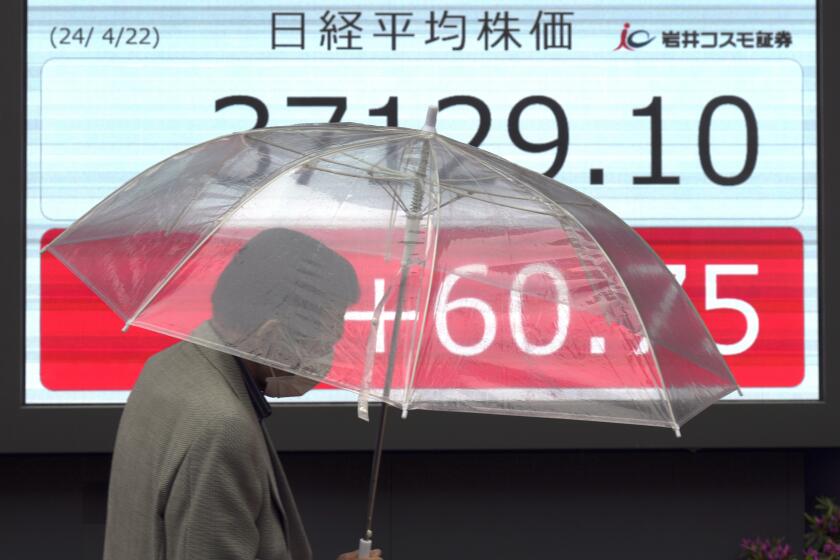 A person walks in front of an electronic stock board showing Japan's Nikkei 225 index at a securities firm Monday, April 22, 2024, in Tokyo. (AP Photo/Eugene Hoshiko)