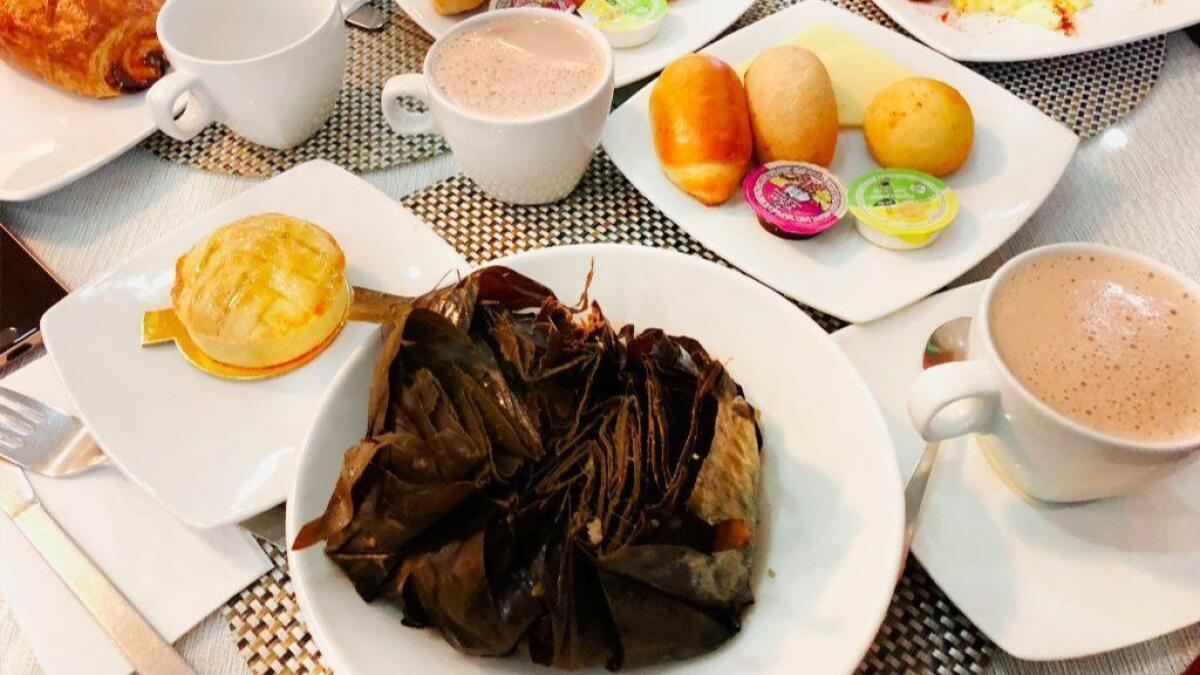 A Colombian breakfast at Pastelería Florida in Bogotá, including the formidable tamal tolimense and a mug of chocolate santafereño.