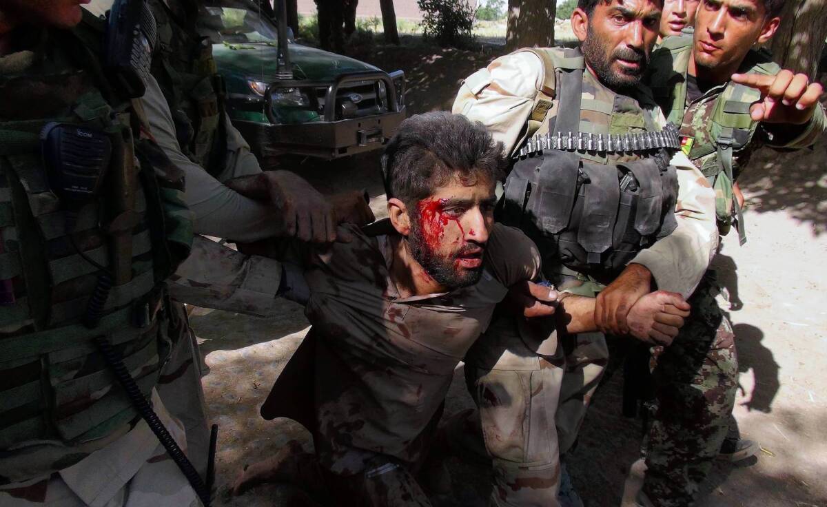 Afghan security forces detain a suspected Taliban fighter injured in a clash with police in Nangarhar province. The fighting came a day before the U.S. and the Taliban were to begin direct talks.