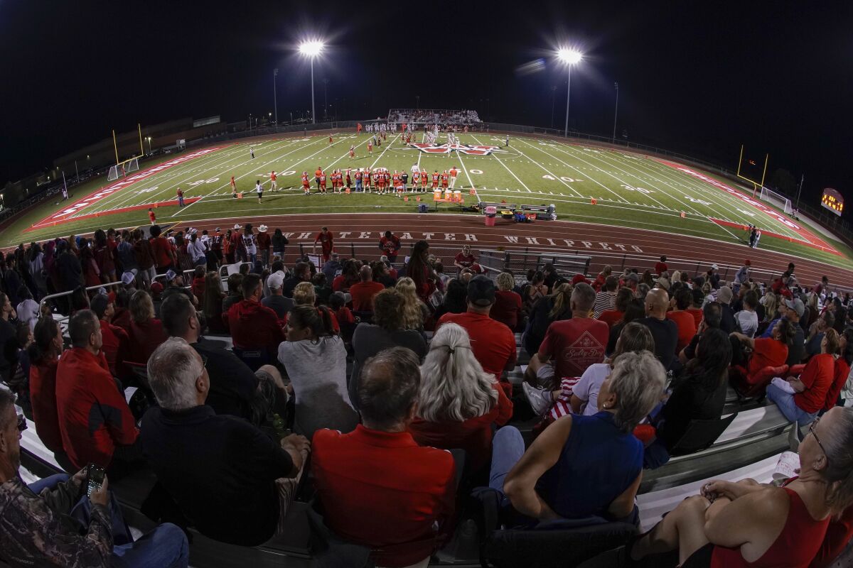 Fans fill the stadium at the football field at Whitewater High School on Friday, Oct. 1, 2021, in Whitewater, Wis. A growing number of school districts in the U.S. are using federal pandemic funding on athletics projects. When school officials at Whitewater learned they would be getting $2 million in pandemic relief this year, they decided to set most of it aside to cover costs from their current budget, freeing up $1.6 million in local funding that’s being used to build new synthetic turf fields for football, baseball and softball. (AP Photo/Morry Gash)