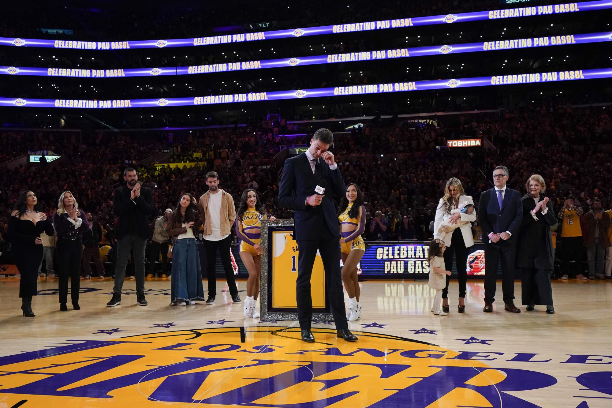 Former Los Angeles Lakers forward Pau Gasol wipes his tears while speaking at his jersey retirement ceremony.