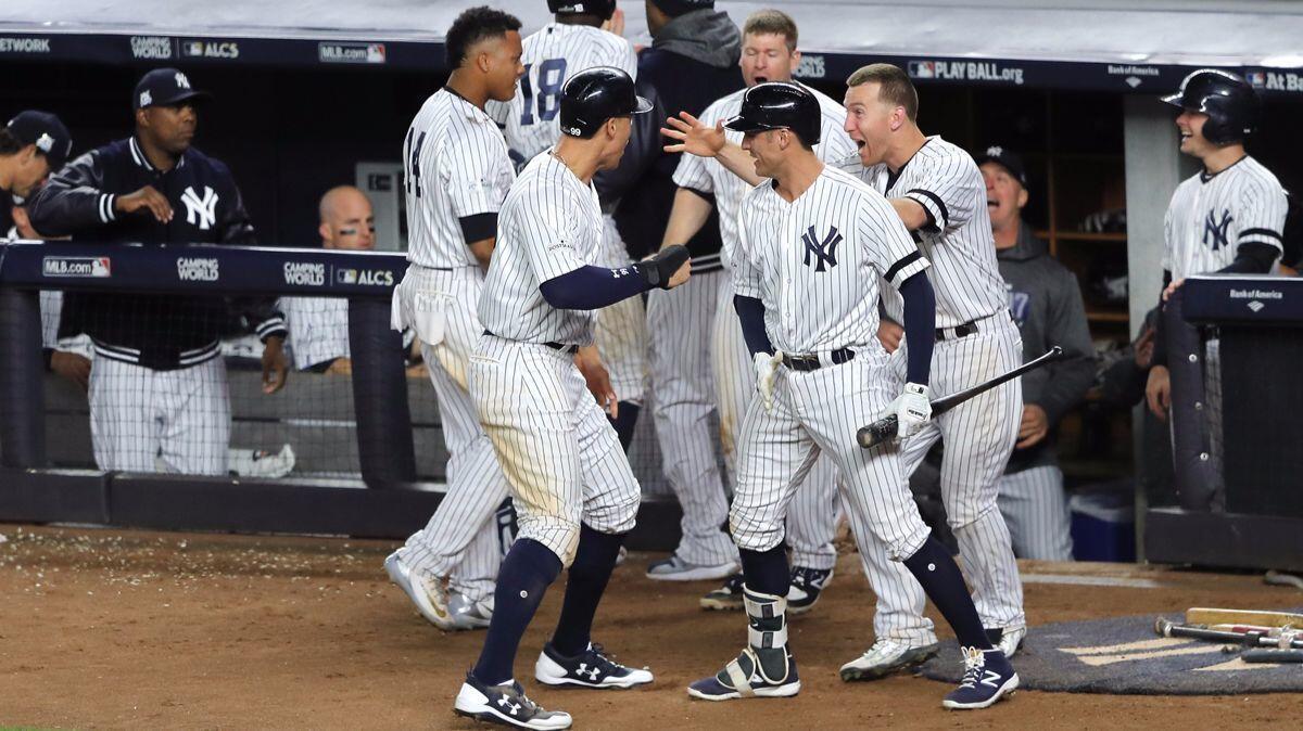 New York Yankees' Aaron Judge, second from left, celebrates after scoring on a Gary Sanchez double against the Houston Astros in Game 4 of the ALCS on Tuesday.