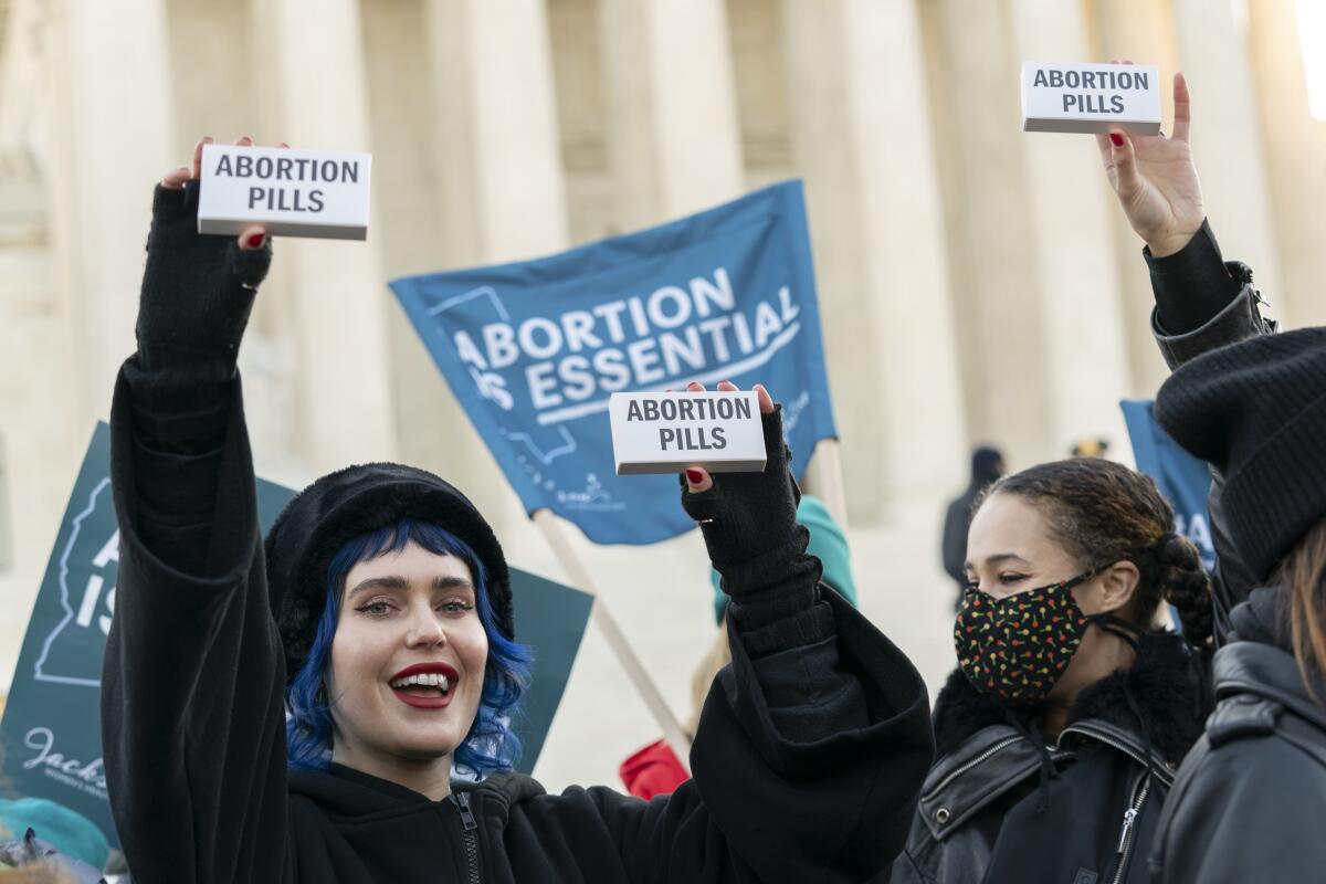 Abortion rights advocates showing packages labeled "Abortion Pills."