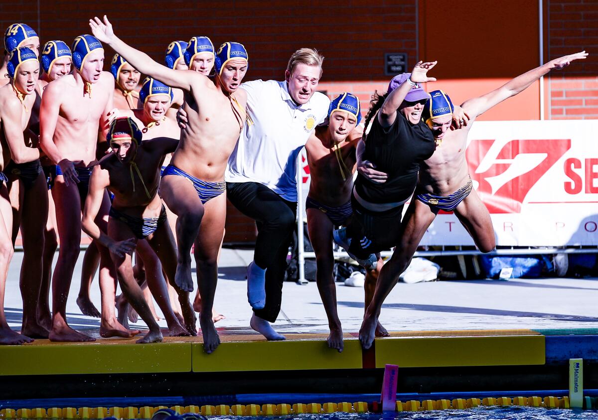El Segundo coach Nila Ward leads a celebratory leap into the pool at Mt. San Antonio College after a 15-7 win Saturday.