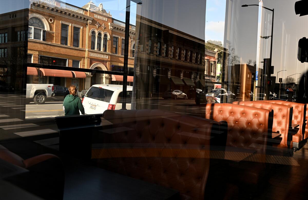 A man and traffic seen through a building in downtown Salinas