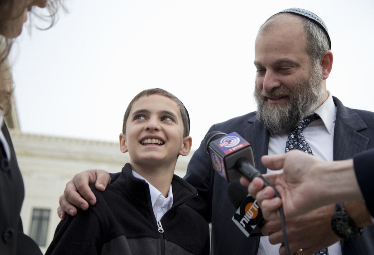 Menachem Zivotofsky and his father Ari Zivotofsky speak to media outside the Supreme Court in Washington on Nov. 3, 2014. The Supreme Court has struck down a disputed law that would have allowed Americans born in Jerusalem to list their birthplace as Israel on their U.S. passports.