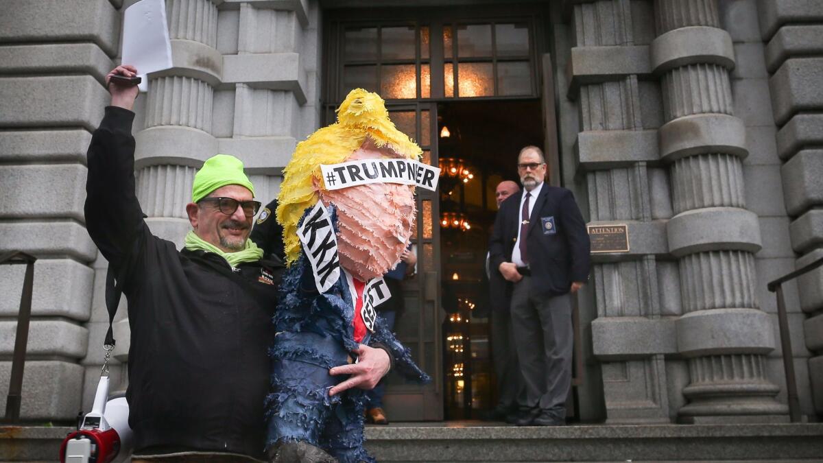 Michael Petrelis holds up a copy of the U.S. 9th Circuit Court of Appeals' decision after it ruled against lifting the stay on President Trump's travel ban.