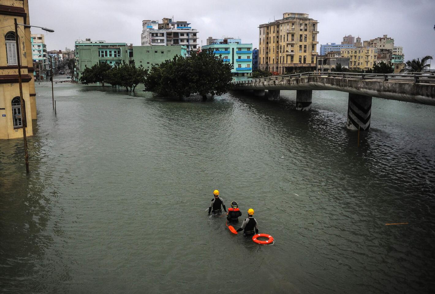 Members of a rescue brigade wade through a flooded street in Havana on Sept.10, 2017.