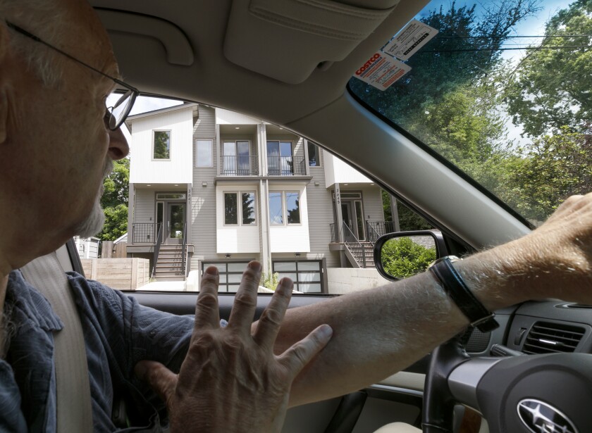 Rod Merrick, president of the Eastmoreland Neighborhood Assn., drives through southeast Portland, Ore., looking at newly built multiple-family dwellings.