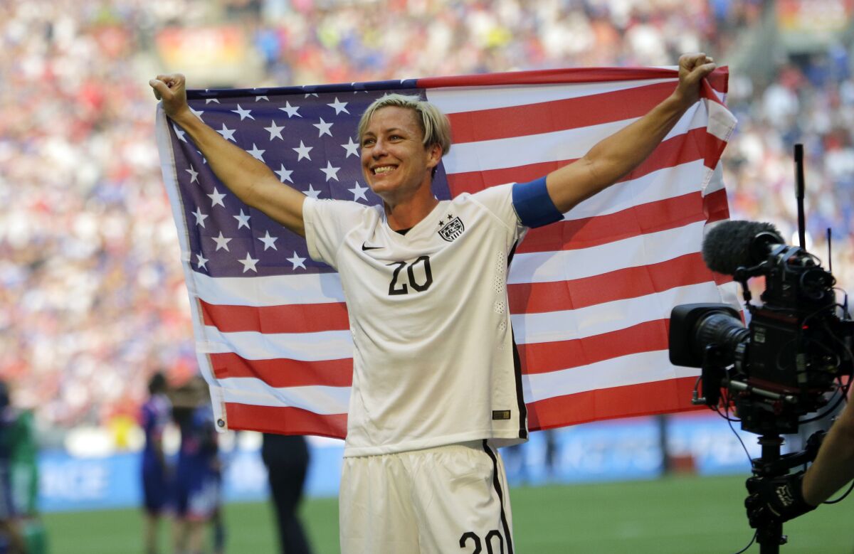 Abby Wambach holds up the U.S. flag after a win over Japan for the 2015 Women's World Cup title.