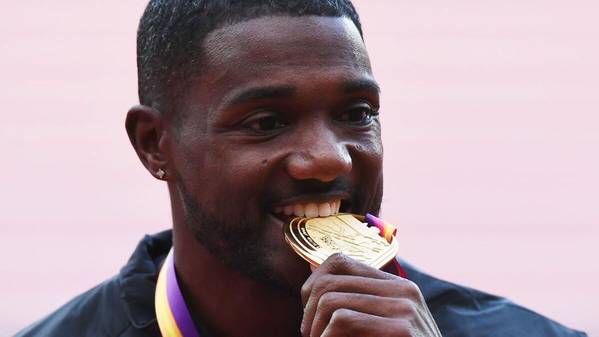 Justin Gatlin poses with his gold medal in the men's 100 meters at the IAAF World Championships in London on Aug. 6.