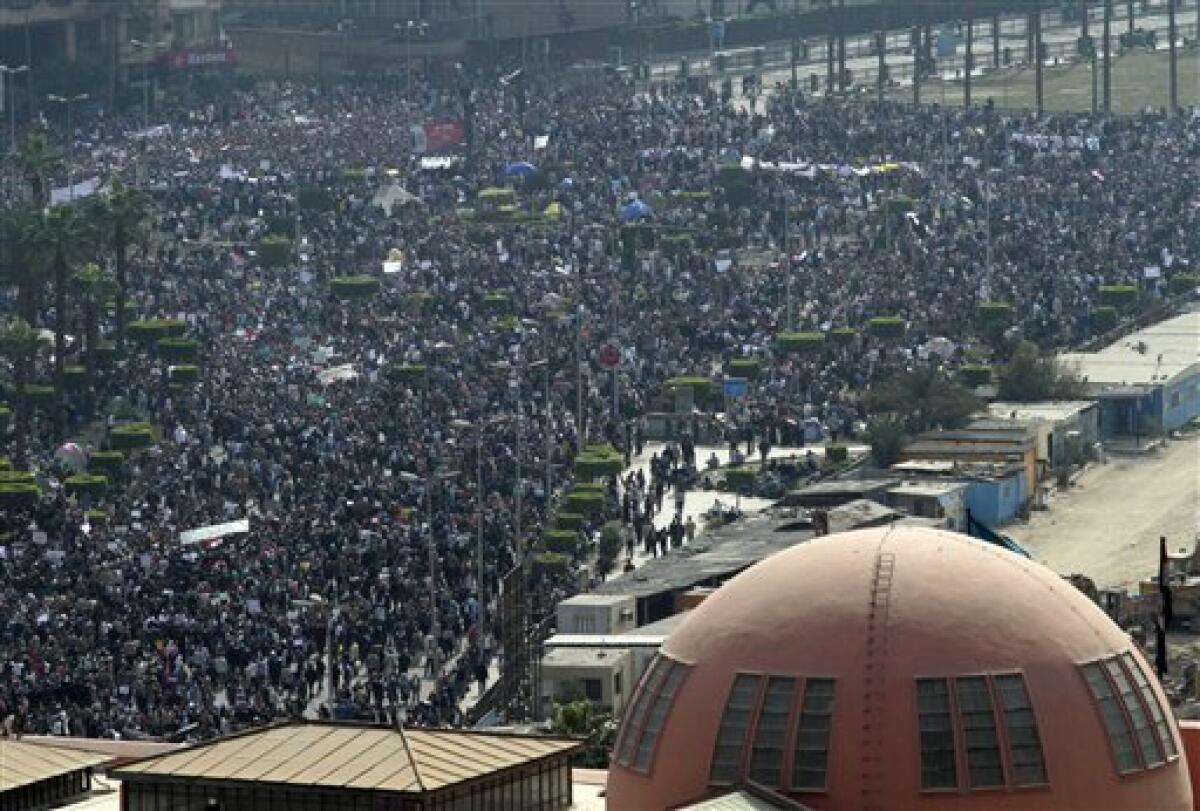 People gather in Tahrir, or Liberation, Square in Cairo, Egypt, Tuesday, Feb. 1, 2011. Security officials say authorities have shut down all roads and public transportation to Cairo, where tens of thousands of people are converging to demand the ouster of Egyptian President Hosni Mubarak after nearly 30 years in power. Part of the Egyptian Museum is seen in the foreground. (AP Photo/Lefteris Pitarakis)