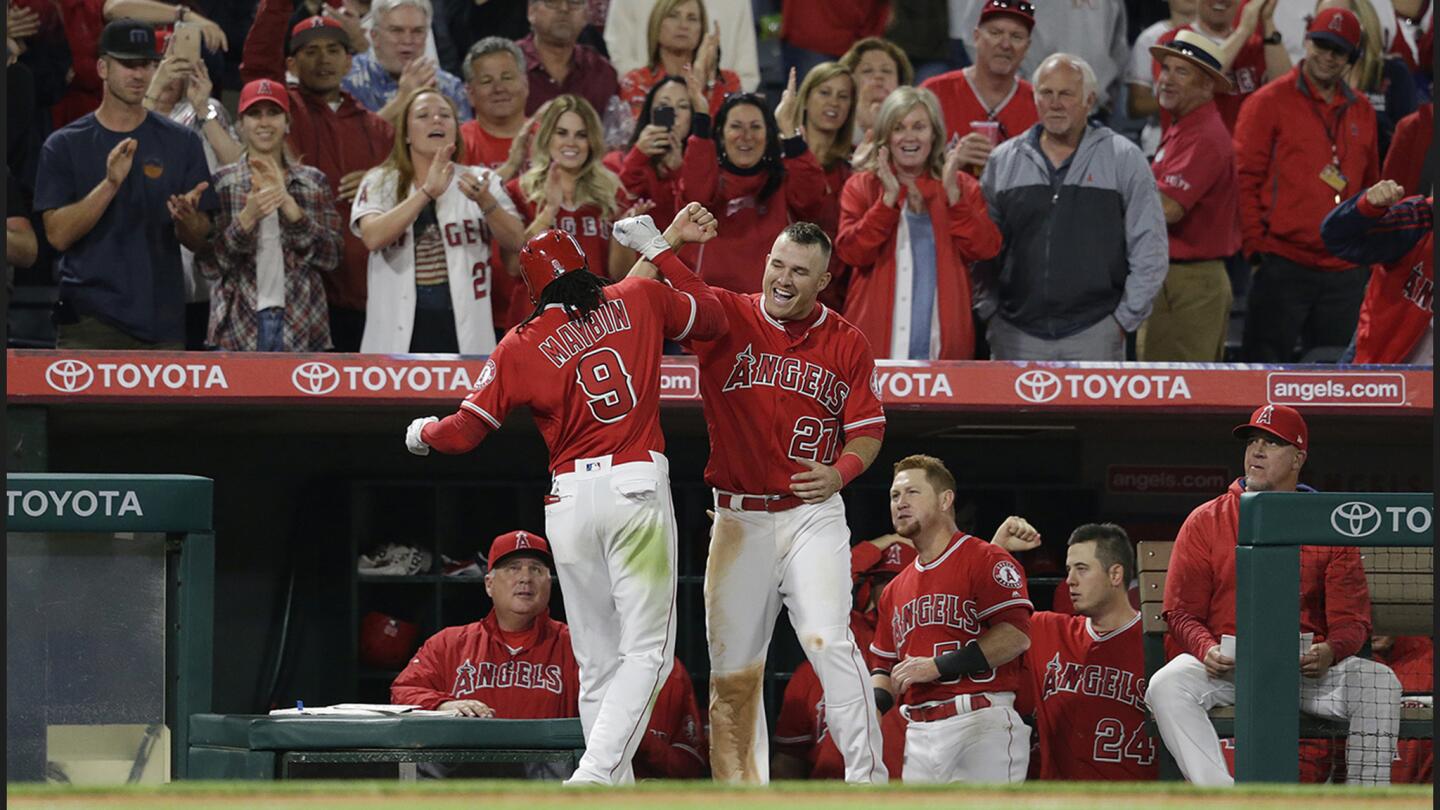 Angels center fielder Mike Trout, right, congratulates Cameron Maybin after his solo homer to give the Angels a 3-1 lead over the Mariners in the sixth inning of a game at Angel Stadium of Anaheim.