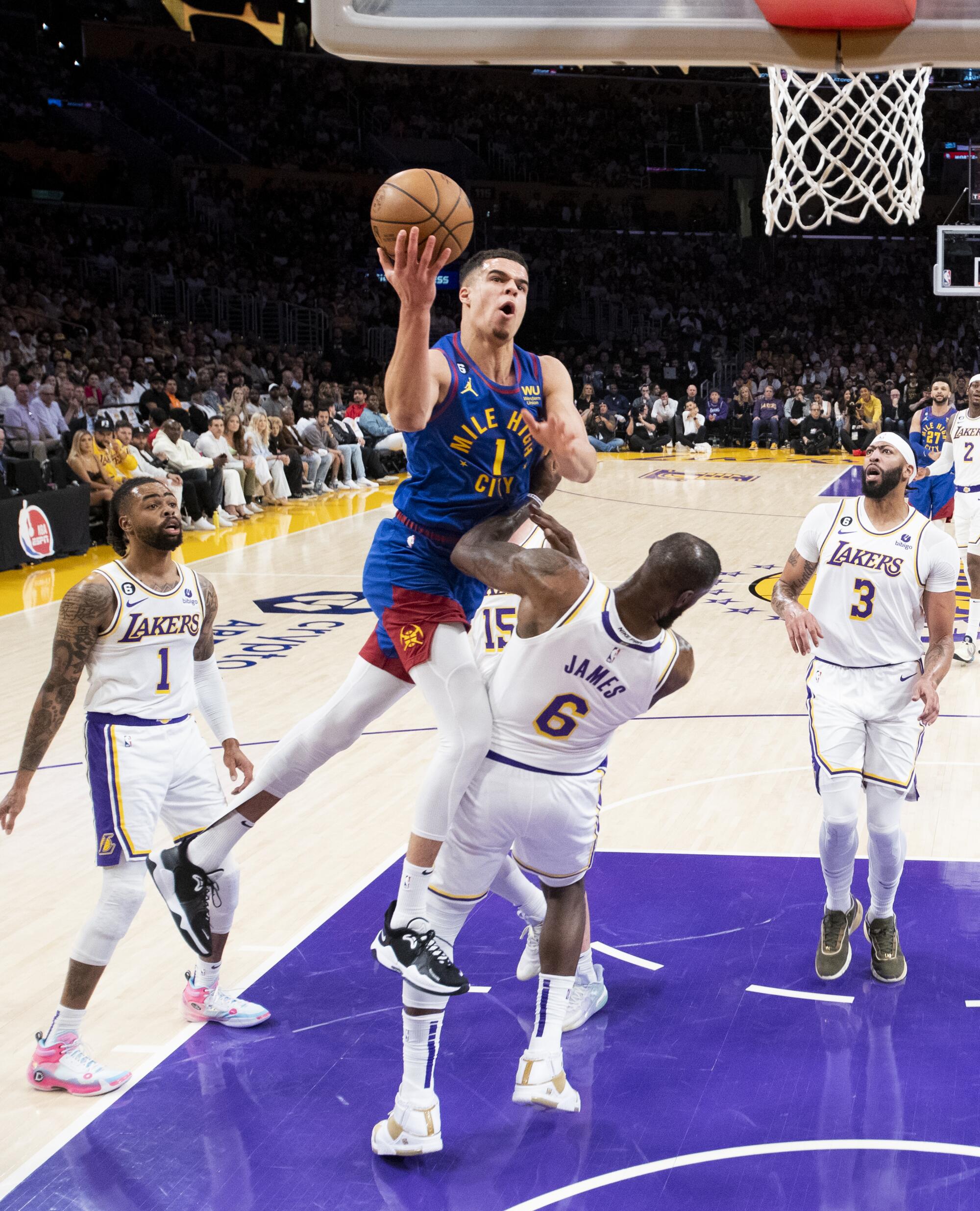 Nuggets forward Michael Porter Jr., left, draws a foul on Lakers forward LeBron James.