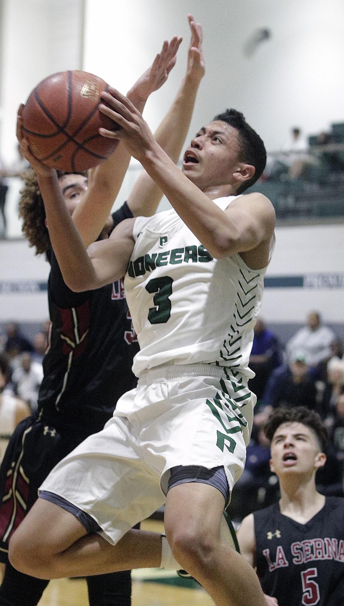 Providence's Bryce Whitaker holds in the air to shoot a layup against La Serna's MJ Aristegui in the CIF Southern Section Division III-AA quarterfinal boys' basketball playoff at Providence High School on Tuesday, February 18, 2020.