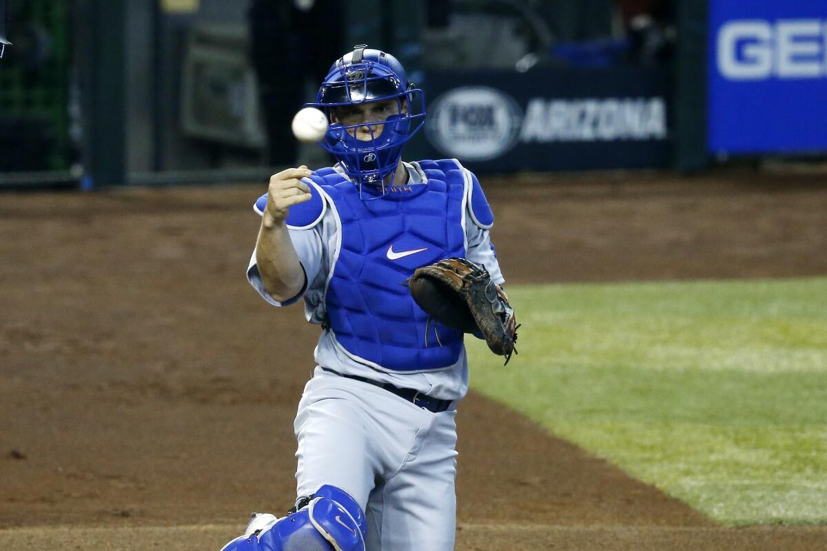 Dodgers catcher Will Smith tosses a ball out of play.