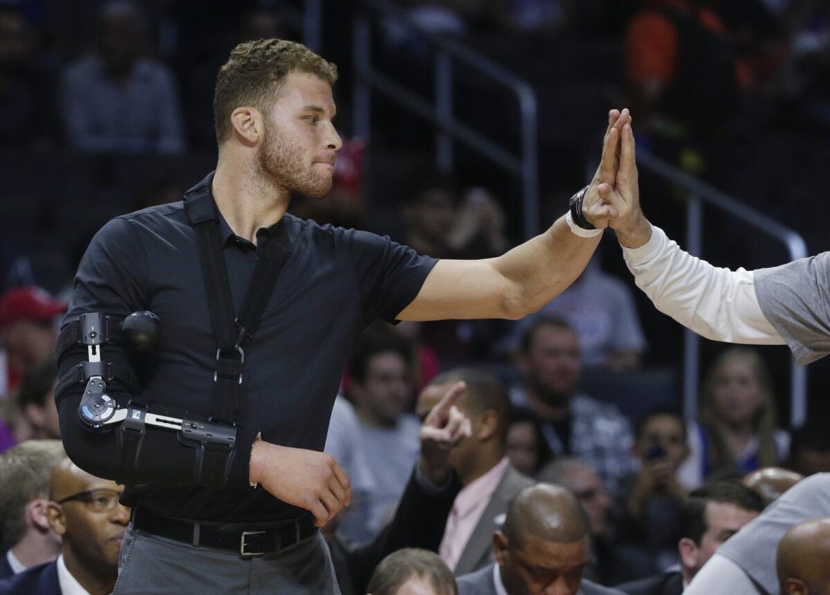 Blake Griffin, who had surgery Monday to remove a staph infection from his right elbow, receives a high-five from a teammate before the Clippers' 110-95 win over the Houston Rockets on Wednesday at Staples Center.