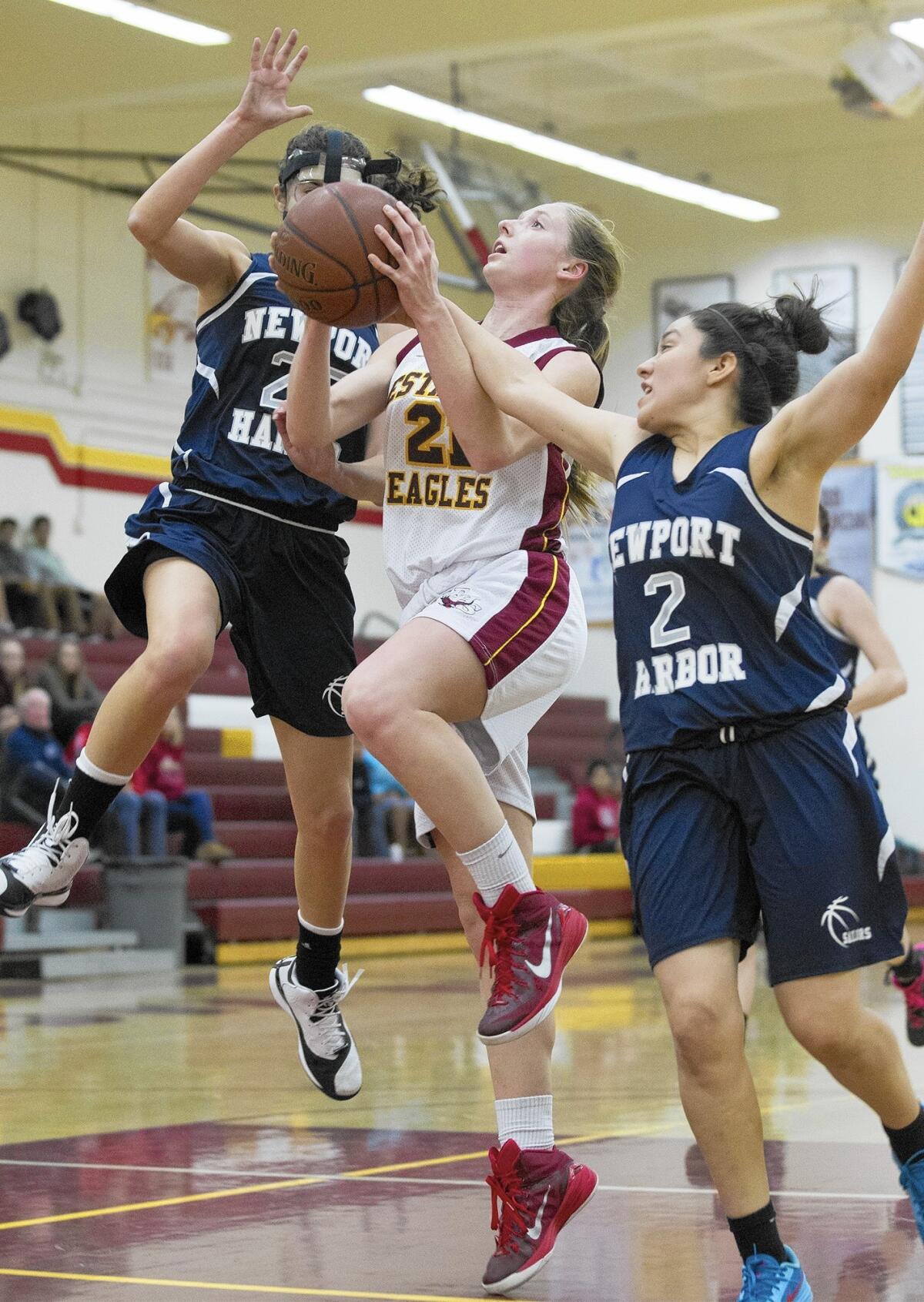 Estancia High's Finley Garnett, center, who scored a game-high 22 points, goes up against Newport Harbor's Lexi Alvarez, right, and McKenna Izzi, left.