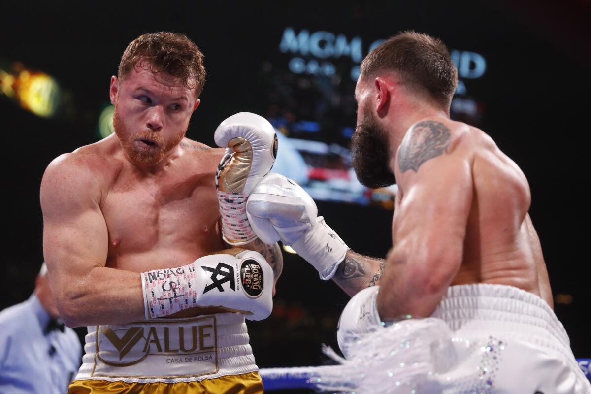Canelo ?lvarez, left, tries to dodge a punch thrown by Caleb Plant during their title fight Saturday.