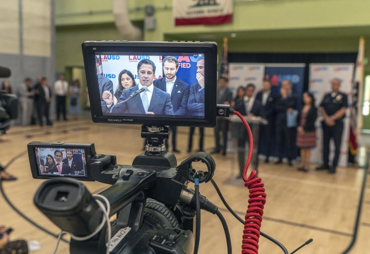 The L.A. schools superintendent on a camera screen in a school gymnasium 