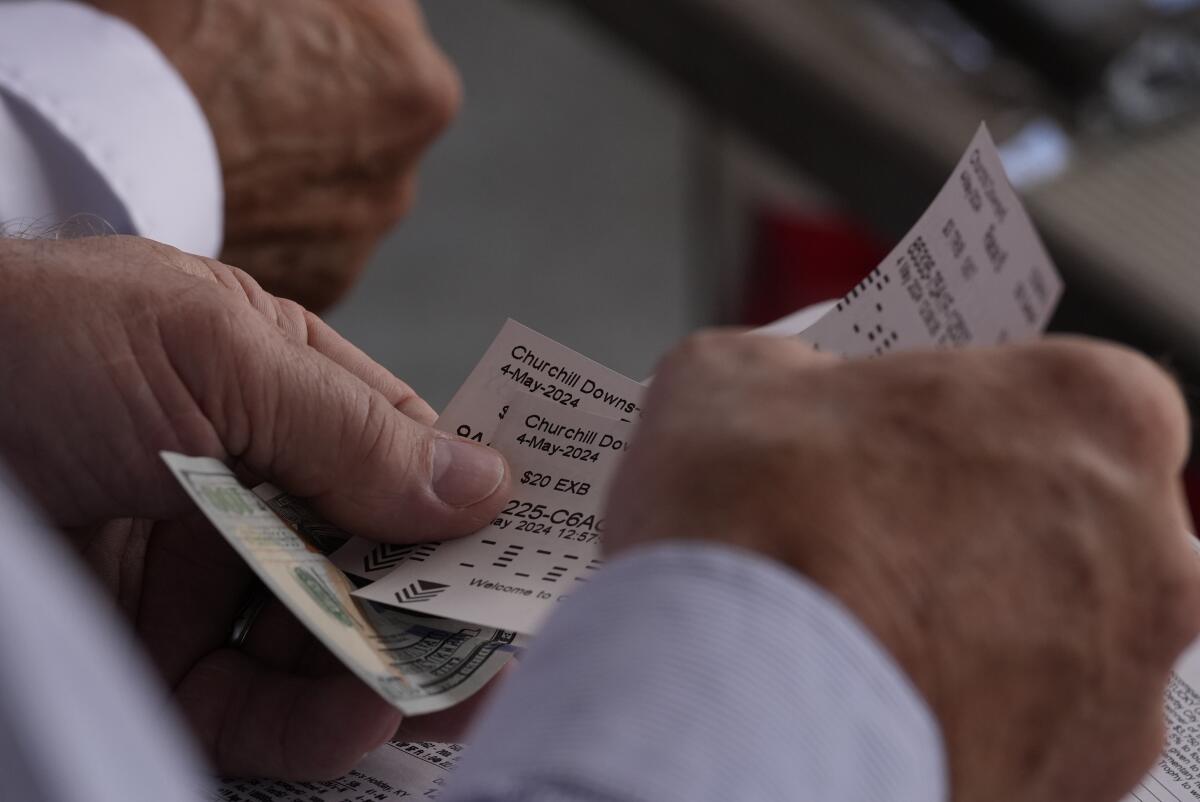 A man holding betting slips.