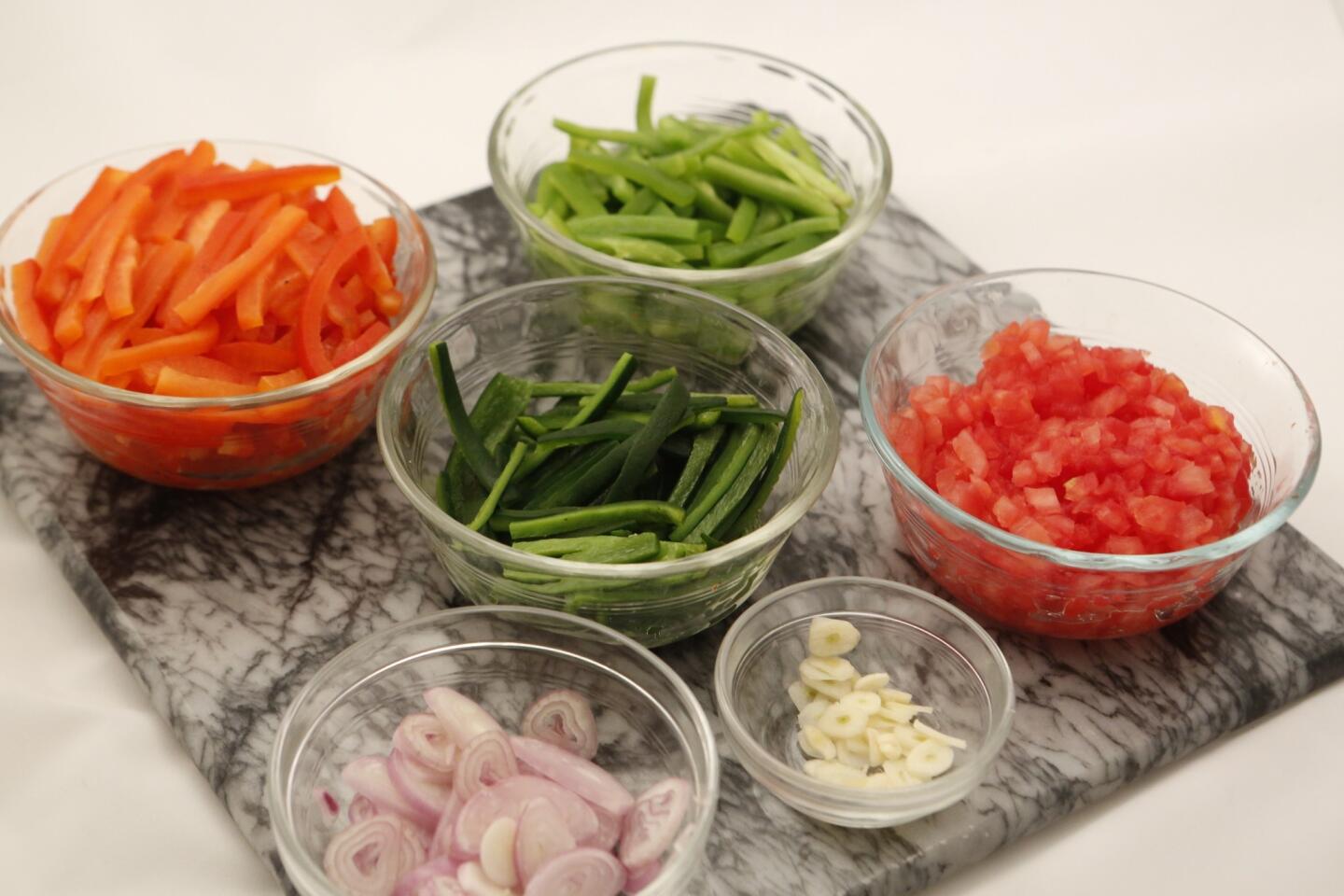 Some of the ingredients: red bell pepper, Poblano pepper, Anaheim pepper, chopped tomato, sliced shallot and garlic.