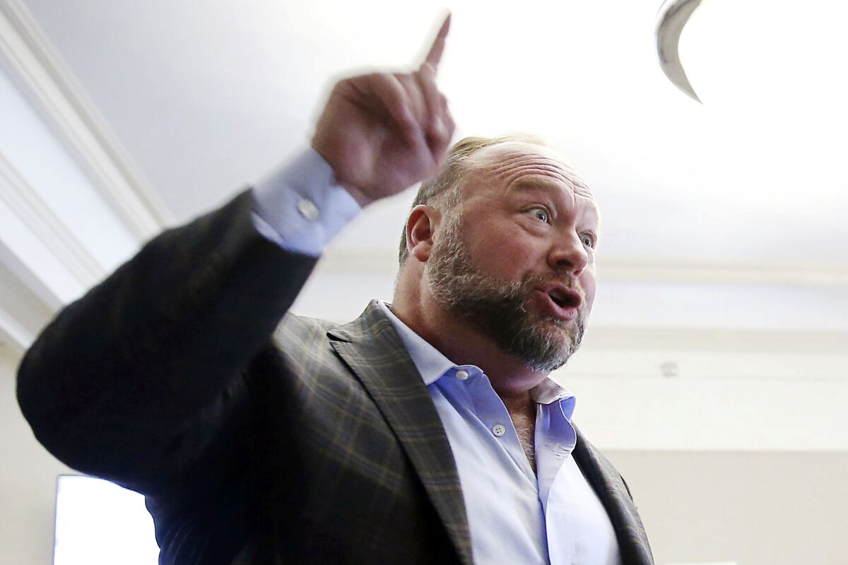 FILE - Alex Jones talks to media during a midday break in his trial at the Travis County Courthouse in Austin, Texas, on July 26, 2022.A Connecticut judge began hearing testimony Wednesday, Aug. 17, 2022, on whether a lawyer for conspiracy theorist Alex Jones should be disciplined for allegedly giving unauthorized people highly sensitive documents, including medical records of relatives of victims of the Sandy Hook Elementary School shooting. (Briana Sanchez/Austin American-Statesman via AP, Pool, File)