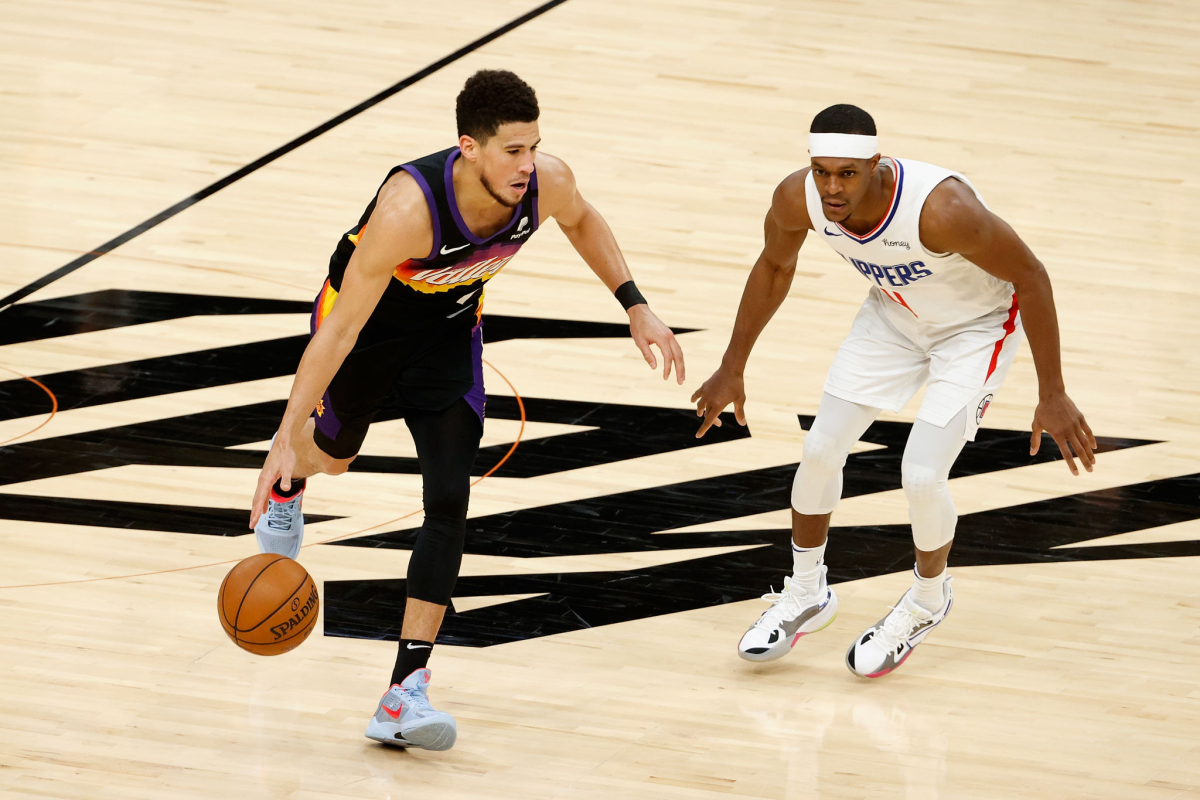  Devin Booker of the Phoenix Suns handles the ball against the Clippers' Rajon Rondo.