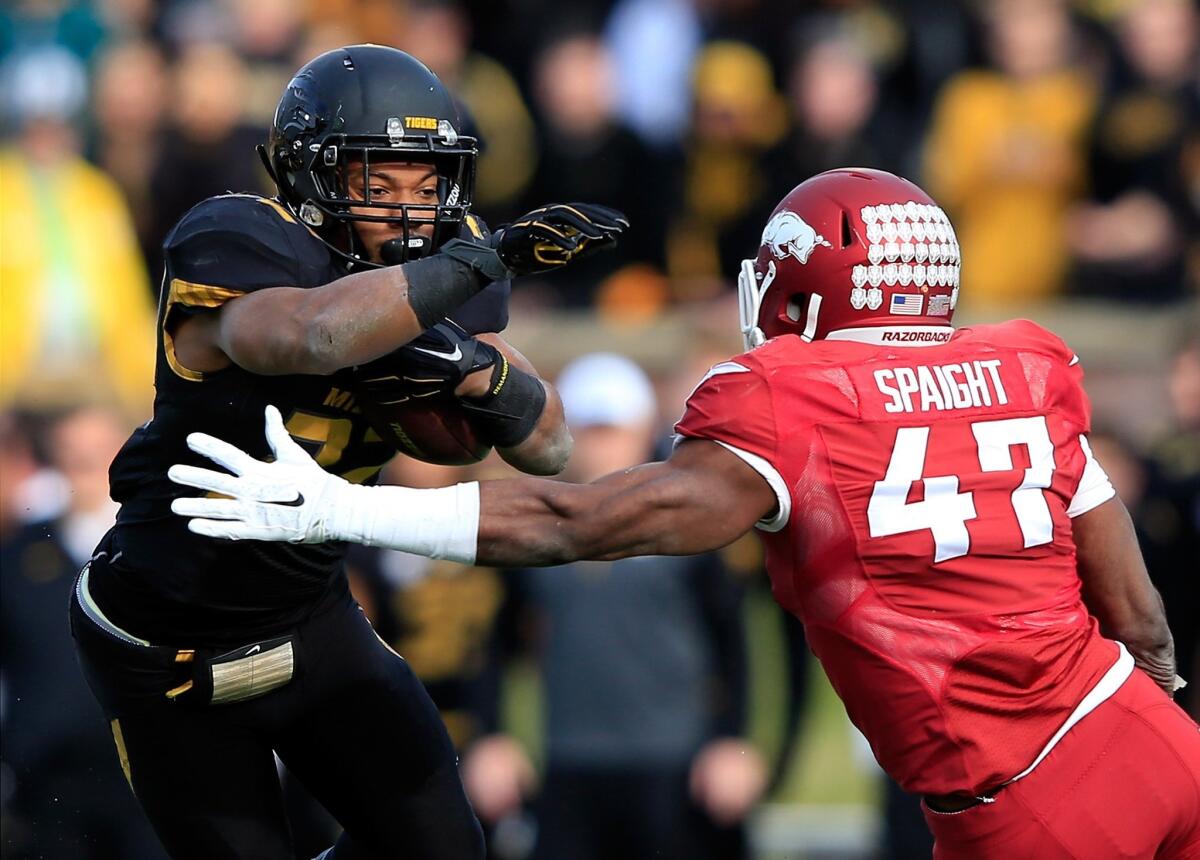 Missouri running back Russell Hansbrough tries to evade Arkansas linebacker Martrell Spaight during their game Friday.
