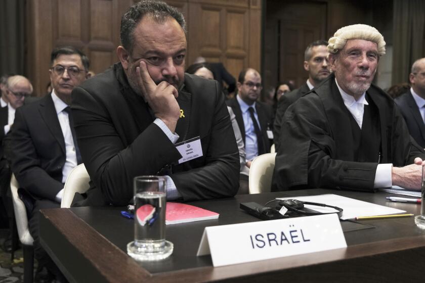 British jurist Malcolm Shaw, right, legal adviser to Israel's Foreign Ministry Tal Becker, left, look on during the opening of the hearings at the International Court of Justice in The Hague, Netherlands, Thursday, Jan. 11, 2024. The United Nations' top court opens hearings Thursday into South Africa's allegation that Israel's war with Hamas amounts to genocide against Palestinians, a claim that Israel strongly denies. (AP Photo/Patrick Post)