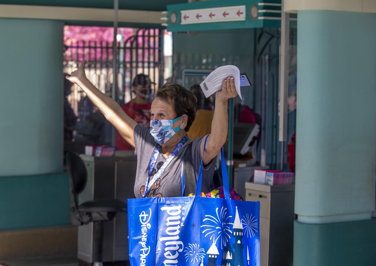A woman in Mickey Mouse T-shirt and carrying a Disneyland tote.