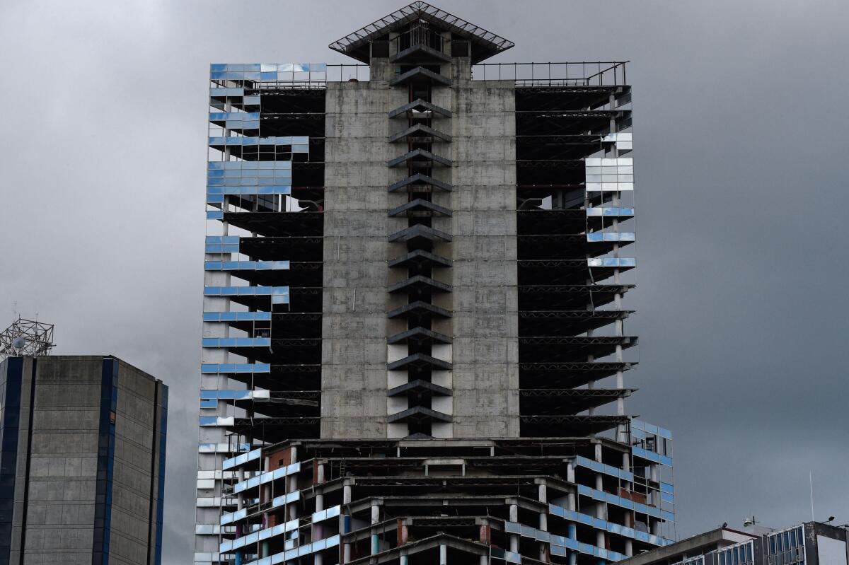 The top of an unfinished Caracas skyscraper has partially installed windows and unfinished detailing. 