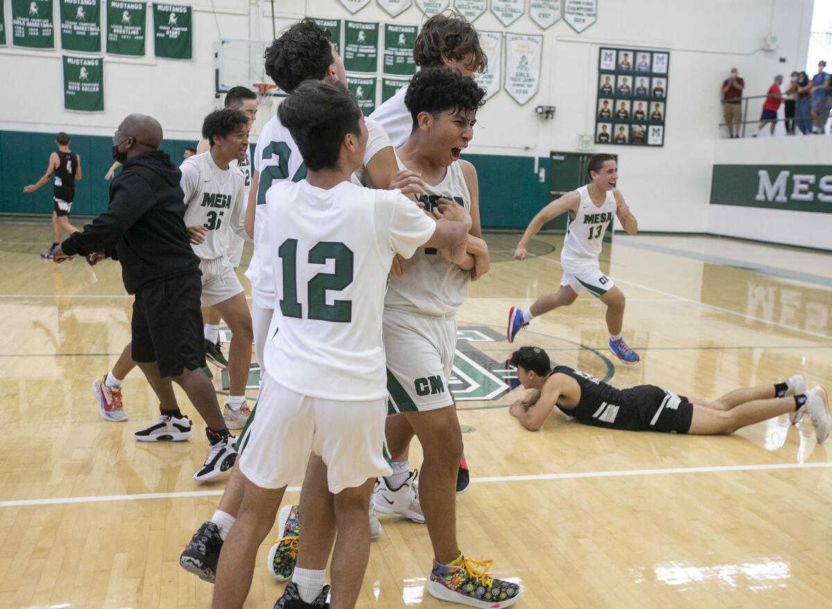 The Costa Mesa High School boys' basketball team celebrates after beating Valley Village Valley Torah on Friday.