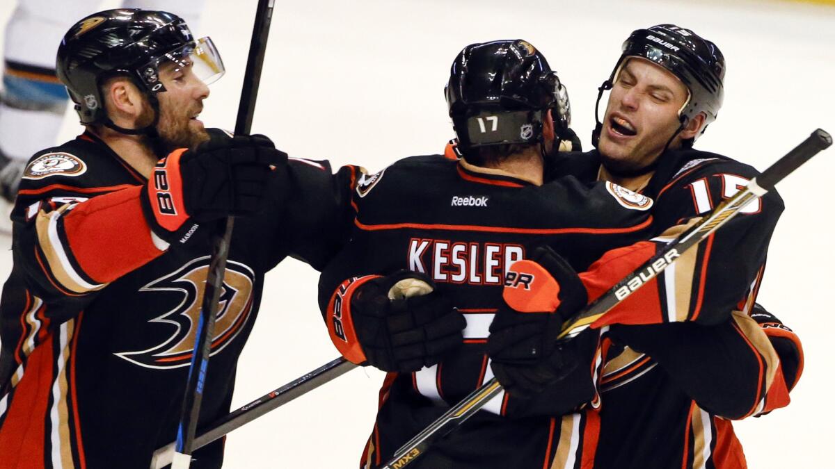 Ducks center Ryan Kesler, middle, celebrates with teammates Patrick Maroon, left, and Ryan Getzlaf after scoring in overtime to lift the Ducks to 3-2 win over the San Jose Sharks on Monday.