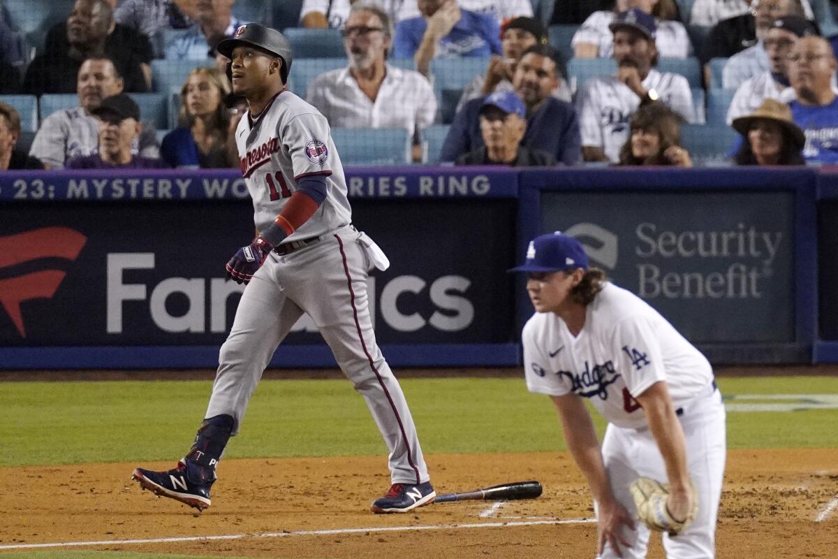 Minnesota Twins' Jorge Polanco, left, heads to first as he hits a three-run home run as Los Angeles Dodgers starting pitcher Ryan Pepiot watches during the third inning of a baseball game Wednesday, Aug. 10, 2022, in Los Angeles. (AP Photo/Mark J. Terrill)