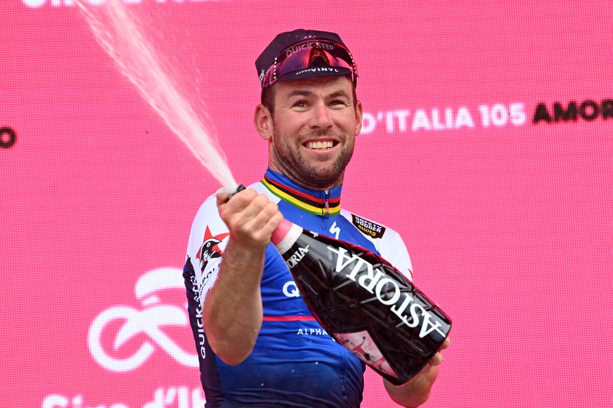 Britain's Mark Cavendish celebrates on the podium after winning the third stage of the Giro d’Italia cycling race, from Kaposvar to Balatonfured, Hungary, Sunday, May 8, 2022. (Gian Mattia D'Alberto/LaPresse via AP)