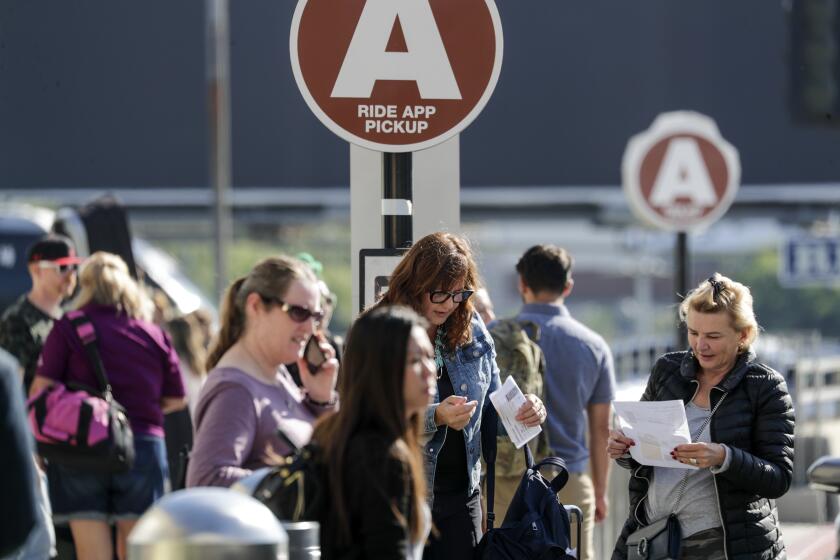 LOS ANGELES, CA - OCTOBER 04, 2019 — Present dedicated ride-hailing spot located on LAX departure level is crowded with departing and arriving passengers. Los Angeles International Airport will soon ban ride-hailing companies from picking up passengers outside its terminals. Starting on or about Oct. 29, travelers looking to hop on an Uber or Lyft will be taken by shuttle to a parking lot next to Terminal 1, where they can book their rides. (Irfan Khan/Los Angeles Times)