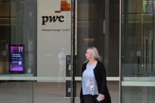 A woman walks out of the offices of PricewaterhouseCoopers (PwC) in Sydney, Monday, May 29, 2023. The Australian branch of the PwC consultancy network announced it had ordered nine partners to take leave as an inquiry examines the leaking of confidential Australian tax avoidance policy changes to multinational corporate clients who could financially benefit from the information. (AP Photo/Rick Rycroft)