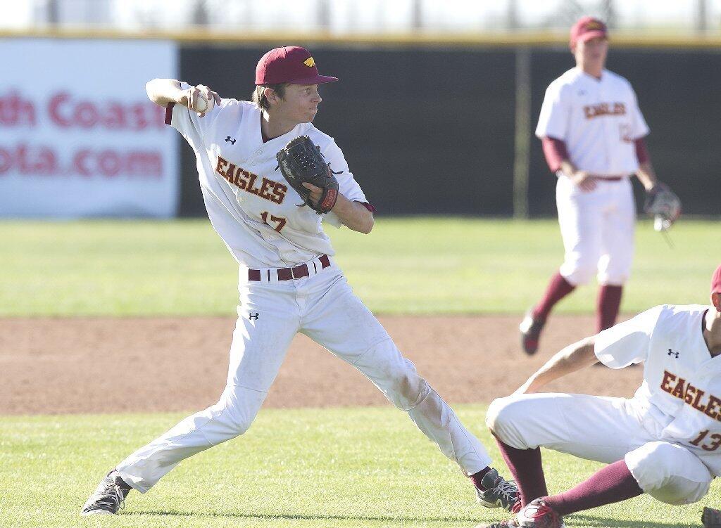 Estancia High pitcher Jake Covey scoops up a bunt and throws to first for an out against Costa Mesa.