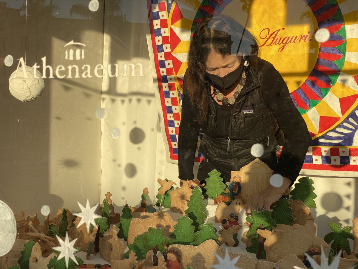 Athenaeum executive director Erika Torri puts the finishing touches on the cookie village.
