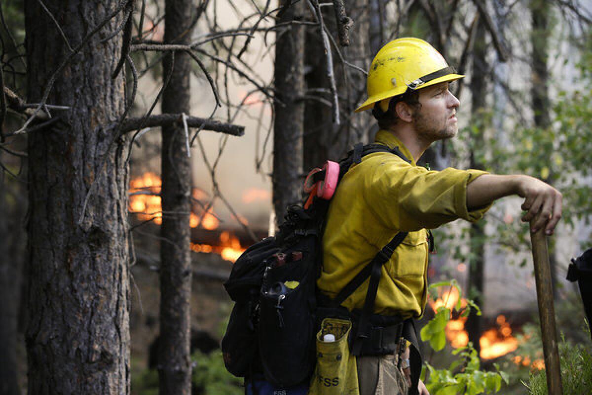 Firefighter Brandon Wenger stands along California 120 while monitoring a backfire intended to impede the Rim fire near Yosemite National Park.