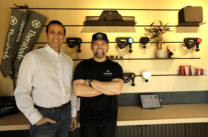 Two men stand inside a store.