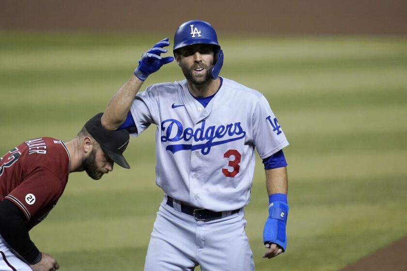 Los Angeles Dodgers' Chris Taylor (3) gets safely back to first base as Arizona Diamondbacks first baseman Christian Walker, left, looks for the baseball during the 10th inning of a baseball game Wednesday, Sept. 9, 2020, in Phoenix. The Dodgers defeated the Diamondbacks 6-4. (AP Photo/Ross D. Franklin)